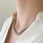 a woman is wearing a silver necklace