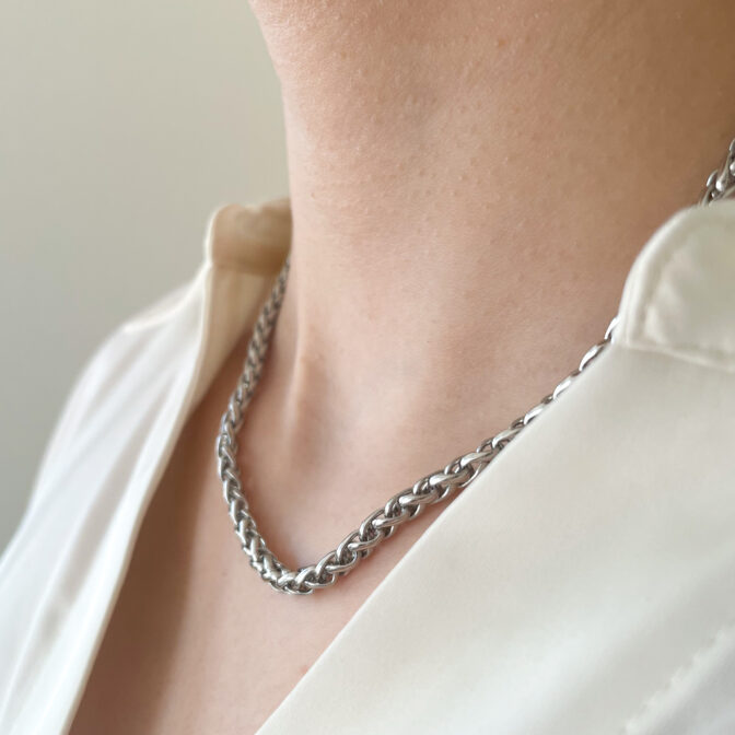 a woman is wearing a silver necklace