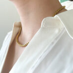 a woman is wearing a gold necklace