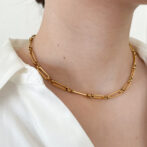 a woman is wearing a gold necklace