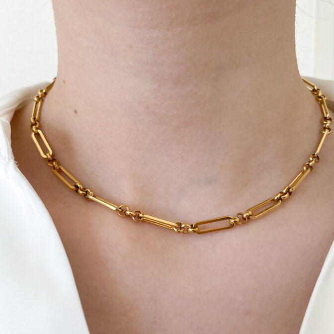 a woman is wearing a gold necklace