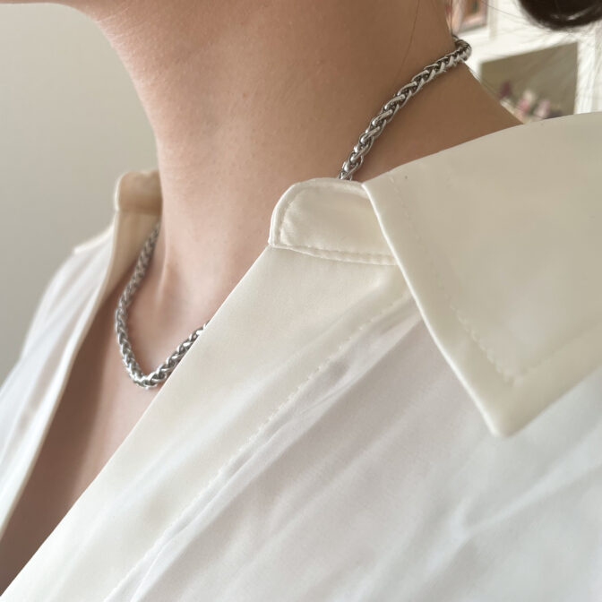a woman is wearing a silver necklace
