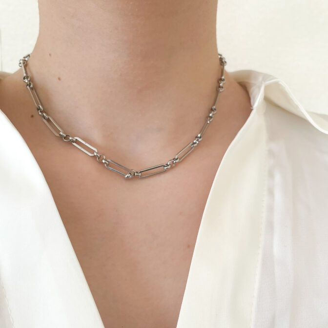 a woman is wearing a silver necklace