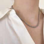 a woman is wearing a silver necklace