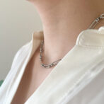 a woman is wearing a silver necklace