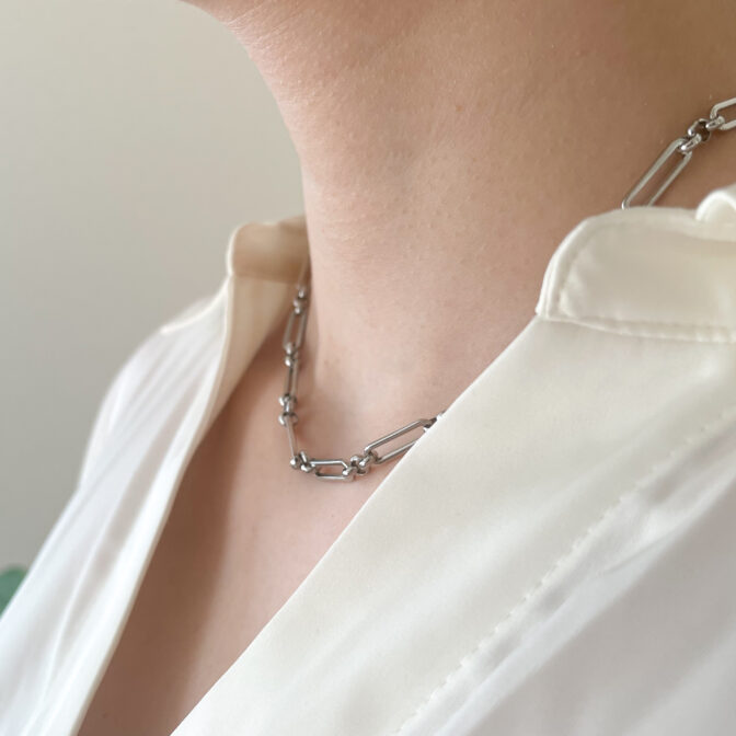 a woman is wearing a silver necklace