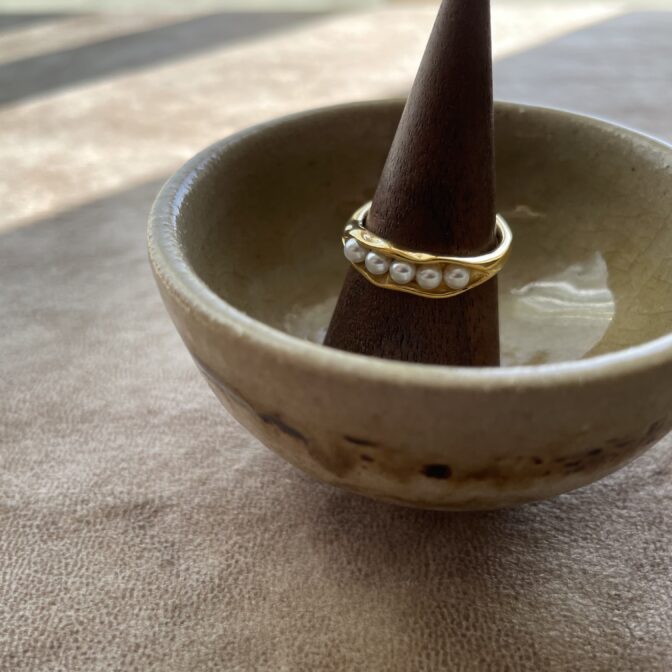 gold ring with pearls on the ceramic plate