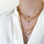 a woman is wearing a gold necklace